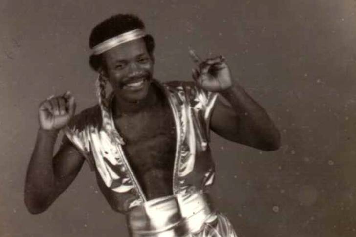 A vintage black and white photograph of a disco artist in flamboyant clothes.